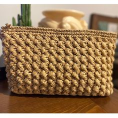 a woven basket sitting on top of a wooden table