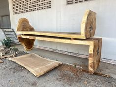 a wooden bench sitting on top of a cement ground next to a building with windows