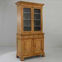 an old wooden china cabinet with glass doors on the front and bottom, against a gray background