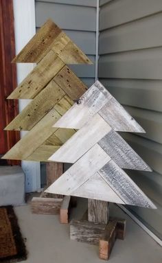 three wooden christmas trees sitting on top of pallets