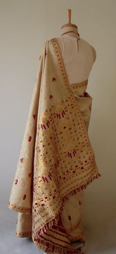 "This is hundred percent authentic Muga Silk Saree . It has Muga silk in the warp and weft . The interwoven motif yarns are in Guna ( golden zari ) and Acrylic. The design is traditional and can be considered as bridal . Muga Silk - The most valued silk from India. Almost exclusively reared and produced in Assam, India. It is indigenous to the Brahmaputra Valley and assiduously practiced in the districts of Assam. The moth is basically a wild moth. Hence it is categorised as Vanya Silk or Wild s Luxury Cotton Silk Saree With Gota Work, Luxury Handloom Dola Silk Traditional Wear, Luxury Traditional Silk Scarf With Zari Work, Luxury Tussar Silk Pre-draped Saree With Dupatta, Luxury Jamawar Traditional Wear With Zari Weaving, Luxury Bohemian Katan Silk Saree, Beige Handloom Traditional Dupatta, Beige Handloom Dupatta For Festivals, Transitional Gold Embroidered Saree