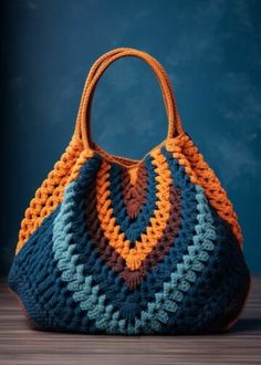 a crocheted bag sitting on top of a wooden table next to a blue wall