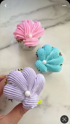 three cupcakes that have been decorated to look like flowers