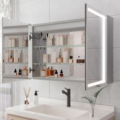 a bathroom sink sitting under a lighted mirror