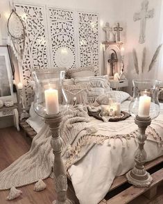 a bed with candles on top of it in a room filled with furniture and decor