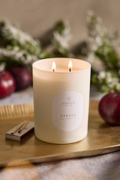 a white candle sitting on top of a wooden tray