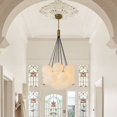 an entryway with stained glass windows and a chandelier hanging from the ceiling