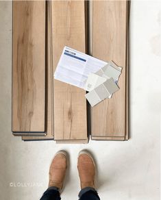 someone is standing on the floor with their feet up in front of some wood cabinets