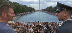 a man in uniform standing at the end of a large pool of water surrounded by people