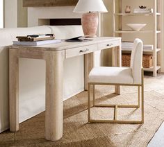 a white desk with a lamp on top and a chair next to it in front of a book shelf