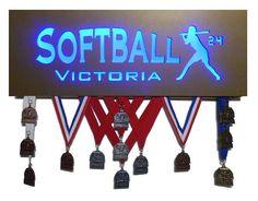 a lighted sign that says softball victoria with bells hanging from it's sides and the words softball victoria below