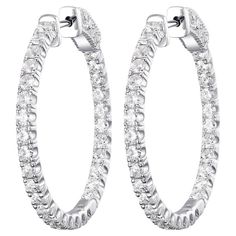 These elegant hoop earrings are crafted from 18K yellow gold, offering a classic and warm aesthetic. Each earring is embellished with a generous array of diamonds, totaling 2.13 carats, that encircle the hoop in a continuous loop of radiance. The diamonds catch and reflect light from every angle, providing a stunning sparkle that is both luxurious and tasteful. The white gold setting complements the brilliance of the diamonds, adding a rich depth to the overall appearance of the earrings. These hoops are designed for secure and comfortable wear, making them perfect for both everyday elegance and special occasions. The timeless design ensures these earrings remain a staple in any jewelry collection, providing a touch of glamour and sophistication to any look. Whether dressing up for an even Earring Video, Modern Hoop Earrings, Warm Aesthetic, Gold Diamond Hoop Earrings, White Gold Hoops, Everyday Elegance, Hoop Earring Sets, Casual Accessories, Diamond Hoop Earrings