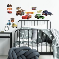 cars wall decals in a bedroom with a black bed and grey blanket on the floor