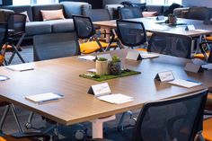 an empty conference room with chairs, tables and notes on the table in front of them