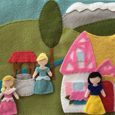 two felt dolls are standing in front of a doll house with a baby's crib