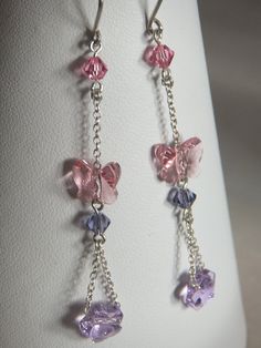 These Sterling Silver, Genuine Swarovski Long Drop earings measure 5.5 cm in length. They are made with a sterling silver shepherds hook, then a pink 4 mm faceted bicone, then a length of sterling silver chain. Next I've attached a pink swarovski butterfly bead followed by a purple 4 mm faceted bicone. Lastly a final length of sterling silver chain passed through a purple flower bead and attached in a loop.     All items of jewellery purchased from my shop will receive a free handmade gift box as shown above. Pink Faceted Earrings For Gift, Pink Faceted Earrings For Jewelry Making, Pink Sterling Silver Crystal Earrings As Gift, Pink Sterling Silver Drop Crystal Earrings, Handmade Pink Crystal Earrings In Sterling Silver, Handmade Pink Crystal Sterling Silver Earrings, Pink Sterling Silver Crystal Earrings Nickel Free, Nickel-free Pink Crystal Earrings In Sterling Silver, Pink Hypoallergenic Dangle Crystal Earrings