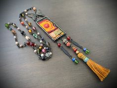 a long necklace with beads and tassels hanging from it's sides on a table