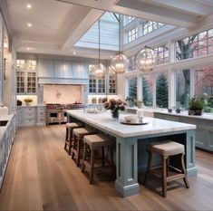 a large kitchen with an island in the middle and lots of windows on both sides