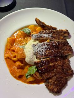 a white plate topped with pasta and meat