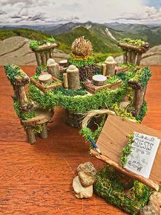 a miniature table and chairs covered in moss