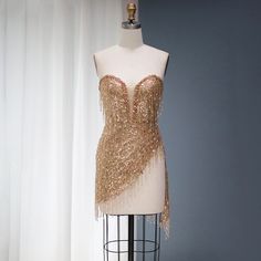 5-7 weeks processing and shipping time This design is from the Bellezza collection. Looking for a dress to make a statement? This copper/gold sequin and tassel mini dress is perfect! This dress is perfect for a birthday party, clubbing, night out or any glamorous occasion.Color may vary due to lighting Material: rhinestones, mesh, polyester Care: hand wash or dry clean only Gold Mini Sequin Dress For Night Out, Gold Sequin Mini Dress For Night Out, Gold Mini Length Sequin Dress For Night Out, Gold Sequined Mini Dress For Club, Glamorous Gold Sequin Mini Dress, Gold Mini Dress For Party Season, Gold Sequin Mini Cocktail Dress, Gold Sequin Mini Dress For Evening, Gold Sequin Dress For Party Season