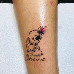 a small tattoo on the leg of a person with a name and a cartoon character