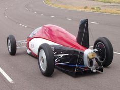 a red and white race car driving down the road