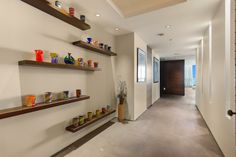 a long hallway with shelves and vases on the wall