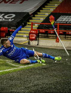 a man laying on the ground next to a soccer ball and a goalie stick