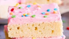 three pieces of cake with pink frosting and sprinkles