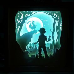 the silhouette of a boy standing in front of a forest with a cat on it