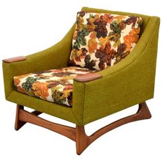 an upholstered chair with floral fabric and wooden legs