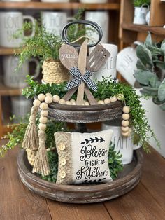 a wooden tray filled with decorative items on top of a table next to potted plants