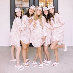 the bridesmaids are wearing matching pink robes and slip on shoes while posing for a photo