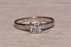 a diamond engagement ring sitting on top of a wooden table