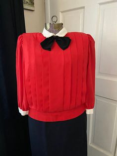 Very fun red vintage professional top. Black bow and white collar accent make this blouse so cute. The added detail of the pleats makes this top a one of a kind. The tight waist ensures that the shirt holds its cute shape no matter the outfit. Neck closures are fully in tact and strong. Classic Collared Pleated Top, Classic Pleated Collared Tops, Classic Red Top For Party, Classic Red Tops For Party, Red Collar Blouse For Work, Classic Red Party Top, Classic Red Party Tops, Vintage Red Top For Formal Occasions, Red Vintage Formal Top