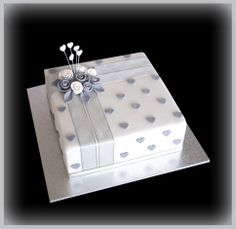 a white box with silver polka dots and flowers on it is sitting on a table