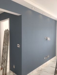 an empty room with blue walls and ladders