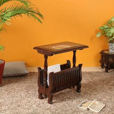 a wooden bench sitting on top of a carpeted floor next to a potted plant