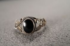 I am offering you this vintage sterling silver wedding band stacker design ring.  This features a raised relief  single stone setting with a twisted flower design. This has a bezel set oval shaped genuine Black Onyx stone set in it.  This ring is currently a size 7 1/4, though I am sure it could be sized up or down. Please review all of my pictures, as they are all a very important part of , my listing/descriptions. Sterling Silver Wedding Band, Vintage Wedding Band, Silver Wedding Bands, Black Onyx Stone, Single Stone, Stone Setting, Onyx Stone, Silver Wedding, Ring Sterling Silver