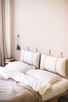 a bed with white sheets and pillows on top of it