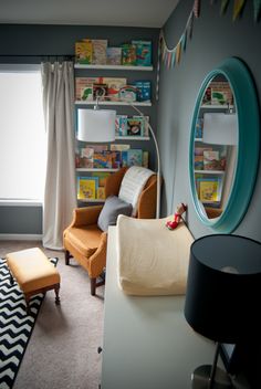 a child's bedroom decorated in gray, orange and yellow with bookshelves