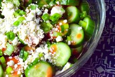 cucumbers and other vegetables are mixed together in a bowl with feta cheese