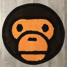 a black and orange rug with a monkey face in the center on a wooden floor