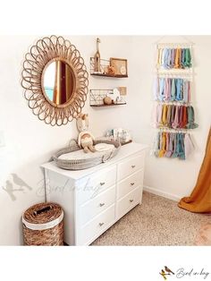 a white dresser sitting under a mirror next to a wall