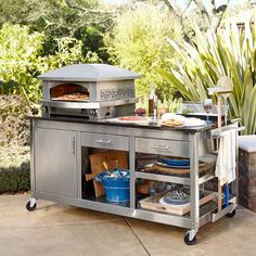 an outdoor grill with food and drinks on it