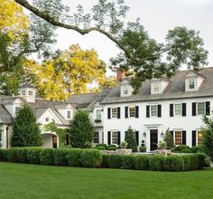 a large white house surrounded by lush green grass