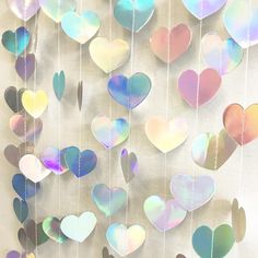 a group of hearts hanging from strings on a wall