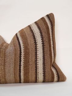 a brown and white striped pillow sitting on top of a table