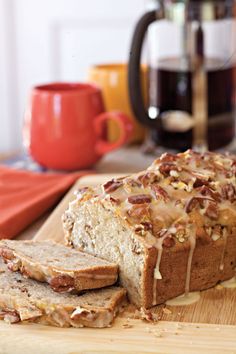 a loaf of bread sitting on top of a wooden cutting board next to sliced bread